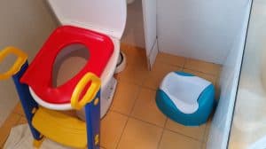 Toilet training setup, complete with stepping stool, potty for baby and towel to catch little leaks. 
